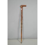 A black forest walking stick with face mask handle.