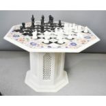 A specimen marble chess table, inset with various coloured marble, with marble chess pieces.