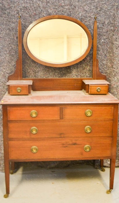 An Edwardian dressing table with oval mirrored back.