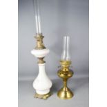 A Victorian ceramic paraffin lamp, and a brass example.