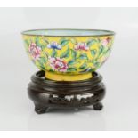 A late 19th century Chinese enamelled hand decorated Famille Rose copper bowl on laquered wooden