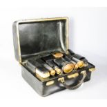 A vintage travelling vanity set, the interior with original bottles, brushes, and manicure set,