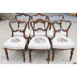 A harlequin set of six victorian rosewood dining chairs with upholstered needlework seats.