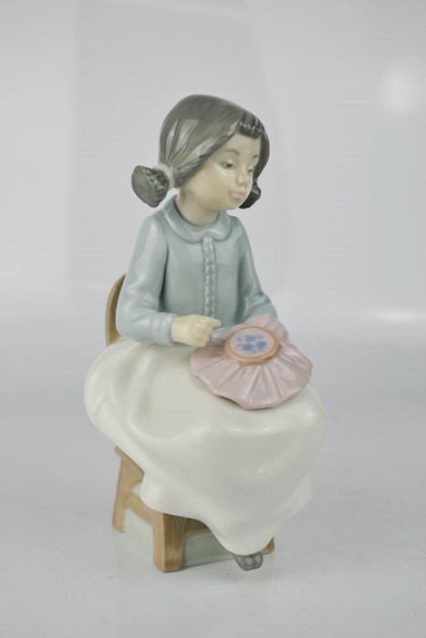 A Nao Lladro figure of young girl sewing, 16cm high.