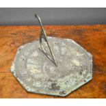 A lead sundial of octagonal form, with green patination.