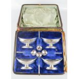 A set of four silver plated salts, with original spoons, boxed.