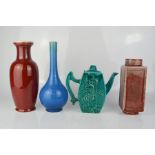 Two Chinese red ground vases, a green glazed tea pot, and a bottle vase in blue.