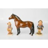 A Beswick pony and two W. Goebel figures.