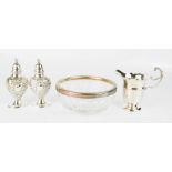 A silver jug, silver presentation spoon in case, a silver rimmed bowl and a salt and pepper.