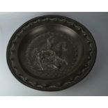 A 19th century pewter embossed dish, depicting St George & the Dragon, 32cm diameter.