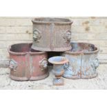 Three cast iron planters, with protruding lion heads, and an urn form planter. The planters