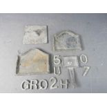 A group of leadwork including house number plaque, sundial and other items.