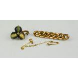 A 9ct gold brooch, safety chain and a brooch in the form of a flower head set with tigers eye.
