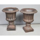 A pair of composition urns, 37cm high.