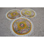 Three circular yellow ground rugs.