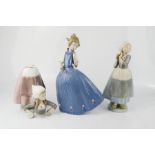 A group of three Lladro figures; two dutch girls and a girl in a blue dress.