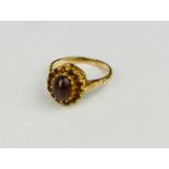 A 9ct gold and garnet ring, with central oval cabochon garnet, 3.8g.