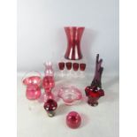 A group of cranberry and other glassware, including vases.