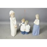 Three pieces of Nao Lladro, pair of choir boys, girl with plaits, and girl in blue skirt.