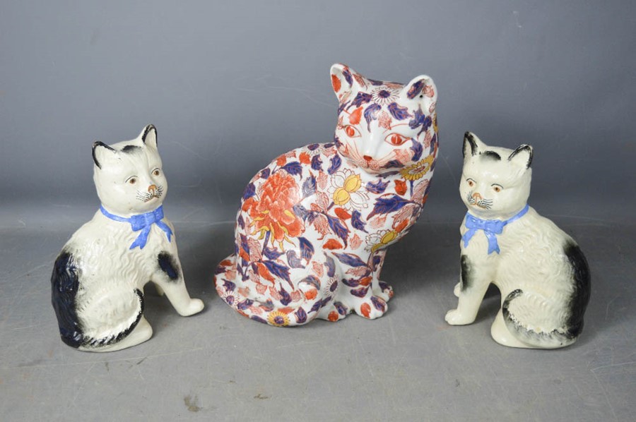 A pair of Victorian ceramic cats (one A/F) and a ceramic cat decorated in a floral pattern.