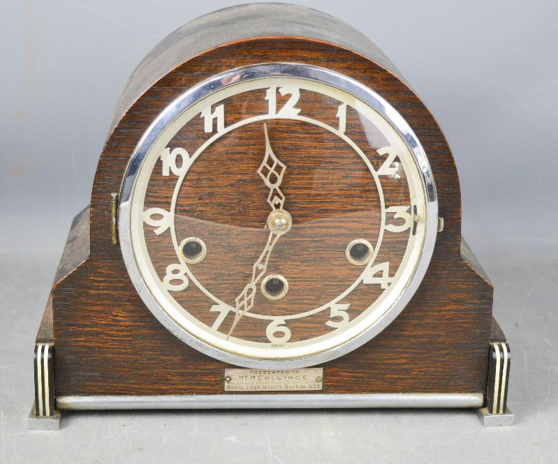 A 1930s mantle clock in oak, with arabic dial and Art Deco style decoration.