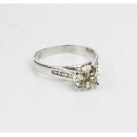 A white gold and diamond solitaire ring, with smaller diamonds to the shoulders, approximately 1.