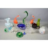A group of murano glass birds, including a dolphin and swan.