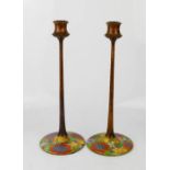 A pair of treen candlesticks with painted floral bases, circa 1940, 32cm high.