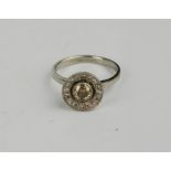 A platinum and diamond 'cupcake' ring with central diamond approximately 0.6ct, bordered by