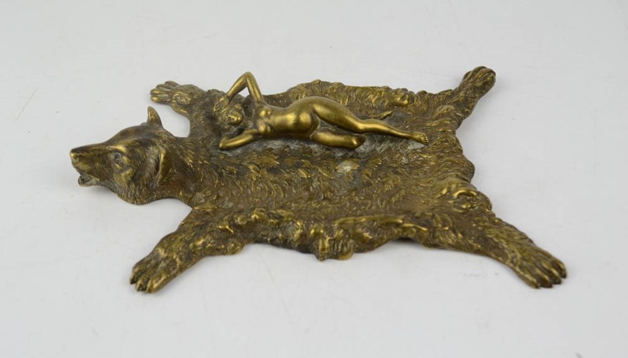 A black forest style brass ashtray, in the form of a bear skin, with a nude reclining woman,18 by