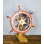 A model ships wheel on stand.