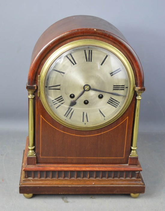 A 19th century mahogany cased dome top mantle clock, with Roman Numeral dial, brass columns, ball