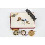 A brooch in the form of a bird composed of feathers, a yellow metal locket, watch chain, key and
