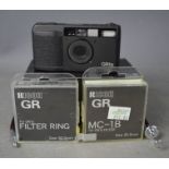 A Ricoh GR1S camera with two filters, all boxed.