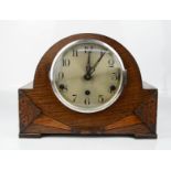 A 1930s mantle clock with oak case, 23cm high.