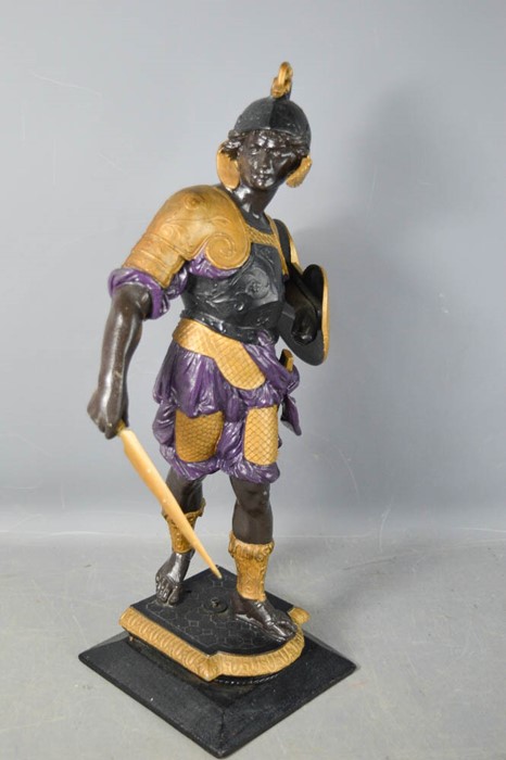 A cast metal figure of a Roman soldier, painted with detail, raised on a plinth, 47cm high.