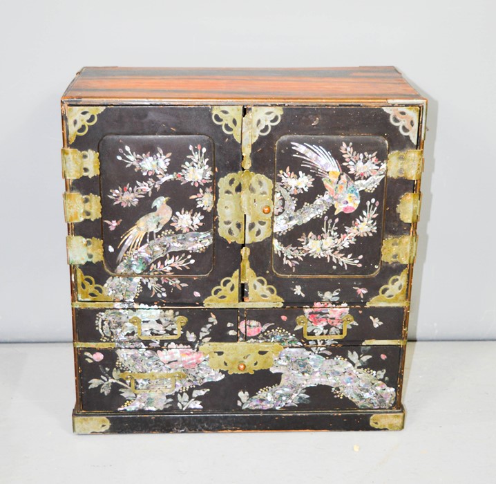 An early 19th century ebonised Chinoiserie decorated cabinet, with mother of pearl inlaid doors,