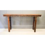 A large hardwood altar table, carved and pierced to the sides, 104 by 210 by 45cm.