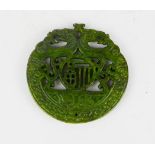 A Chinese natural heitian green jade carved medallion pendant./