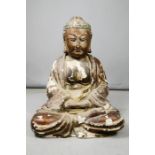 A large carved wooden buddha with residual polychrome, 67cm high.