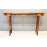 A large hardwood altar table, carved and pierced to the sides, 106 by 176 by 41cm.