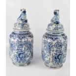 A pair of Delft blue and white Chinoiserie jars & covers, with dog of fo finials, 39cm high.