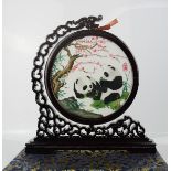 A Chinese silk embroidery depicting two pandas, in a circular frame raised on a bracket mount, in