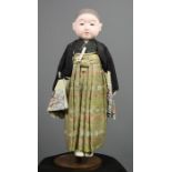 An Ichimatsu doll, c.1960s, wearing hakama and haori, 49cm long. [Ichimatsu dolls are named after