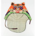 An early 20th century boy's tiger hat, embroidered with King character mark, symbolises the will