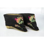 A pair of Chinese lotus shoes circa 1920, embroidered on black silk to depict Peaches and Buddhas