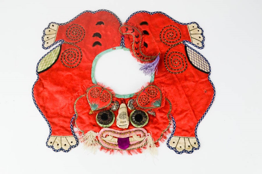 An early 20th century Chinese boys tiger collar, symbolising protection, red silk ground with