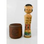 A wooden Japanese doll and a Chinese carved treen jar.