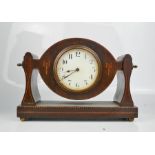 A mahogany inlaid mantle clock with adjustable dial.