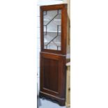 An 18th century oak corner cupboard in two sections, a glazed upper section with white painted